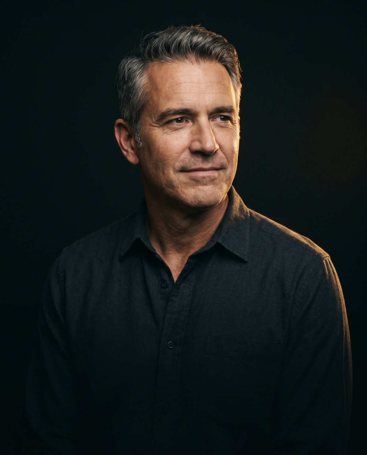 Confident man in his fifties, low-key studio portrait